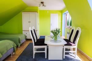 Zimmer mit grünen Wänden sowie einem Tisch und Stühlen in der Unterkunft Agroturystyka Krężniczanka in Lublin