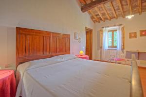 Un dormitorio con una cama grande con cabecero de madera. en Maggiano by PosarelliVillas, en Certaldo