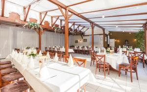 un salón de banquetes con mesas y sillas blancas en Hotel Grasberger Hof GmbH, en Grasberg