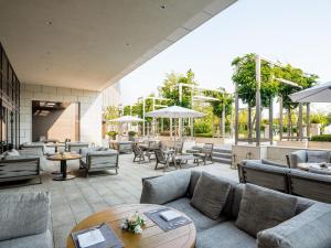 d'une terrasse avec des canapés, des tables et des chaises. dans l'établissement Paradise City, à Incheon