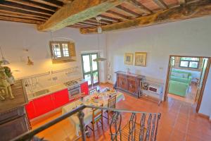 cocina grande con armarios rojos y mesa en Maggiano by PosarelliVillas, en Certaldo