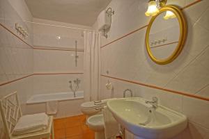 Un baño con lavabo, inodoro y espejo. en Maggiano by PosarelliVillas, en Certaldo 24 fotos más