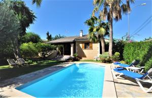 uma piscina com duas cadeiras e uma casa em "PEP POMAR" Chalet en Palma de Mallorca em Palma de Maiorca