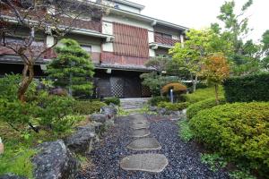 un jardín con un camino de piedra frente a una casa en Matsushima Koumura, en Matsushima