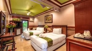 a hotel room with two beds and a desk at Flushing Meadows Resorts & Playground in Panglao Island +57 photos