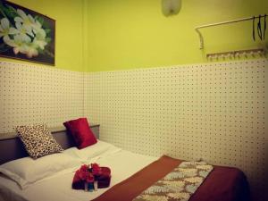 1 dormitorio con 1 cama con 2 almohadas rojas en Weng Kong Homestay, en Slim River