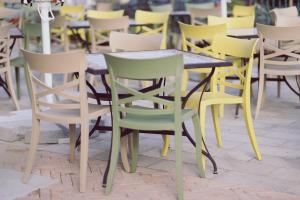 a group of chairs and a wooden table and chairs at Villa Piazzetta in Bacău