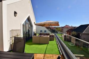 a balcony with a patio furniture and an umbrella at Mandarin Premium Apartments in Târgu-Mureş