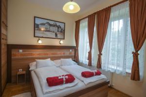 1 dormitorio con 1 cama con 2 almohadas rojas en Centrum Vendégház, en Eger