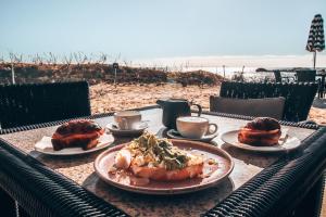 una mesa con platos de comida y café en la playa en Discovery Resorts - Rottnest Island, en Rottnest Island