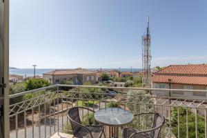 a patio with a table and chairs on a balcony at Orion Residence Mani in Agios Nikolaos