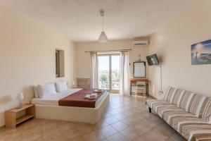a large bedroom with a bed and a couch at Orion Residence Mani in Agios Nikolaos