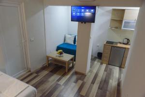 um pequeno quarto com um sofá azul e uma cozinha em City Center Studio em Strumica