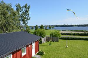 a red house with a flag pole in the yard at River Motel - Selfservice Check in - Book a room, make payment, get pincode to the room in Haparanda