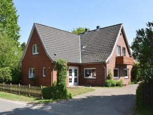 une maison en briques rouges avec un toit noir dans l'établissement Ferienwohnung Lahann, à Bokelrehm