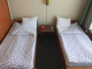 zwei Betten in einem kleinen Zimmer mit einem Tisch in der Unterkunft OTEL ÇINAR in Erzurum