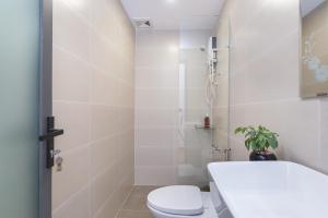a white bathroom with a toilet and a shower at Cozrum Homes Lý Chính Thắng in Ho Chi Minh City +52 photos