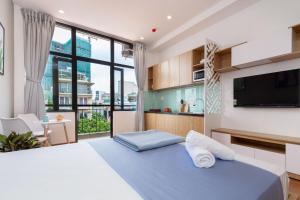 a bedroom with a large bed and a tv at Cozrum Homes Lý Chính Thắng in Ho Chi Minh City