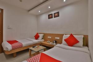 a hotel room with two beds and a table at HOTEL HARMONY in Vadodara +23 photos