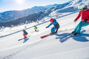 a group of people skiing down a snow covered slope at Rickys Apartment Flachau in Flachau