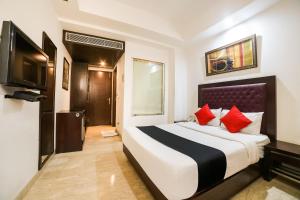 ein Hotelzimmer mit einem Bett und einem TV in der Unterkunft Hotel Livasa Inn Near BLK Hospital in Neu-Delhi