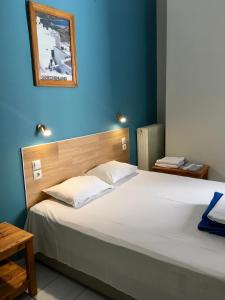a bedroom with a large white bed with a blue wall at Hotel Kastoria in Thessaloniki