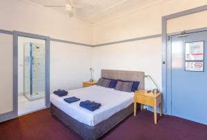 Een bed of bedden in een kamer bij Commonwealth Hotel