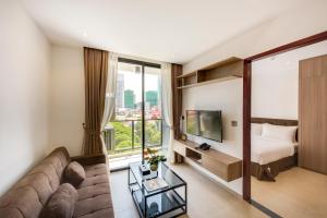 uma sala de estar com um sofá, uma cama e uma televisão em Residence 105 Hotel and Apartment em Phnom Penh