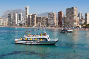 łódź w wodzie z miastem w tle w obiekcie View apartments in Gemelos XV w mieście Benidorm