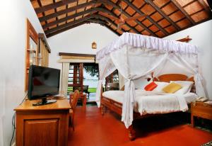 a bedroom with a bed and a tv in it at Punnamada Resort in Alleppey