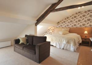 ein Schlafzimmer mit einem Bett und einem Stuhl in der Unterkunft Priory hotel in Cartmel