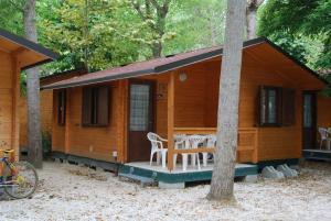 een kleine houten hut met een tafel en stoelen bij Campeggio Boscoverde in Torre del Lago Puccini