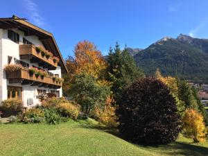 una casa en una colina con montañas en el fondo en Landhaus Frenes Apartments, en Seefeld in Tirol