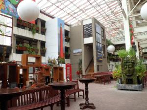 un bâtiment avec des tables et des bancs et une horloge au milieu dans l'établissement Hotel Den Helder, à Le Helder