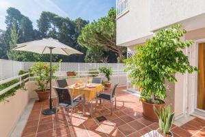 patio ze stołem, krzesłami i parasolem w obiekcie Casa Limonar Málaga w Maladze