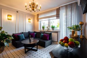 a living room with a couch and a table with a bowl of fruit at Willa Krakowska in Raszyn