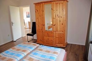 ゲーレンにあるFerienwohnung 01のベッドルーム1室(大きな木製キャビネット、ベッド1台付)