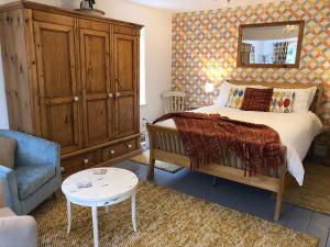 a bedroom with a bed and a chair and a mirror at Dongola Bed & Breakfast in Wool