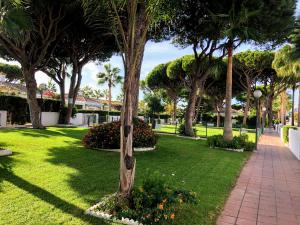 a park with palm trees and a walkway at Apartamento Zinna in Chiclana de la Frontera