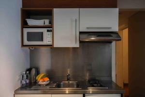 a kitchen with a sink and a microwave at Sky Suites in Beirut