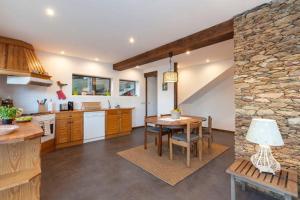 eine Küche mit einem Tisch und einer Steinmauer in der Unterkunft Refugio da Raposa in Caminha