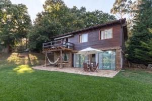 eine Blockhütte mit Veranda und Spielplatz in der Unterkunft Refugio da Raposa in Caminha