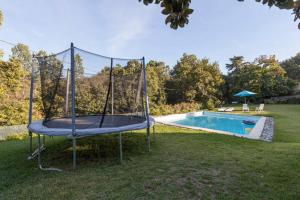 ein Trampolin im Gras neben einem Pool in der Unterkunft Refugio da Raposa in Caminha