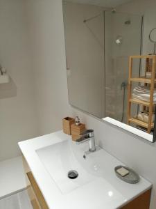 ein Badezimmer mit einem weißen Waschbecken und einem Spiegel in der Unterkunft Chimihome in Córdoba