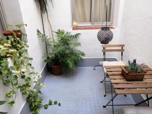 eine Terrasse mit Tischen und Topfpflanzen und einem Fenster in der Unterkunft Chimihome in Córdoba