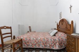 una camera con letto, sedia e cassettiera di La Torre Antica Dimora a Giuggianello