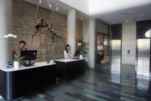 two people sitting at desks in a lobby at ARTOTEL Thamrin Jakarta in Jakarta