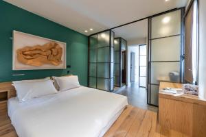 ein Schlafzimmer mit einem weißen Bett und einer grünen Wand in der Unterkunft Hidesign Athens Acropolis Panorama Suite in Athen