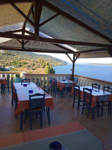 um restaurante com mesas e cadeiras e vista para a água em Agnanti Hotel em Kalamakia