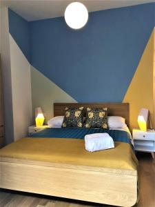 um quarto com uma cama com uma parede azul e amarela em Viaggio da Bea al Gianicolo em Roma